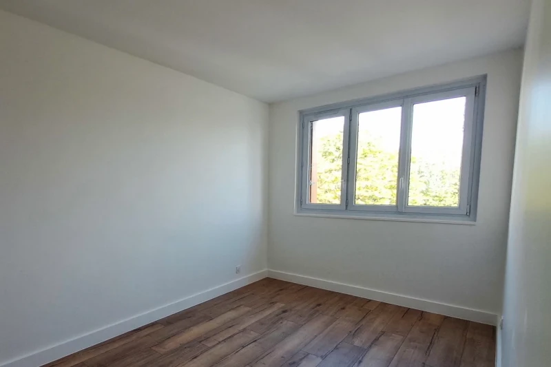 Après travaux : la même chambre, murs blancs, plinthes et parquet neufs