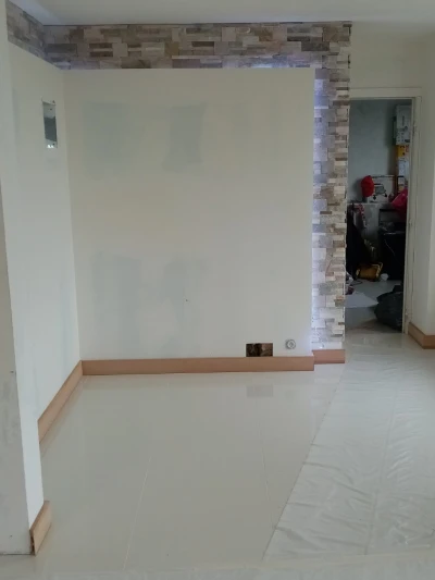 Pendant les travaux : le salon de Longjumeau, parement en pierre posé, murs encore bruts